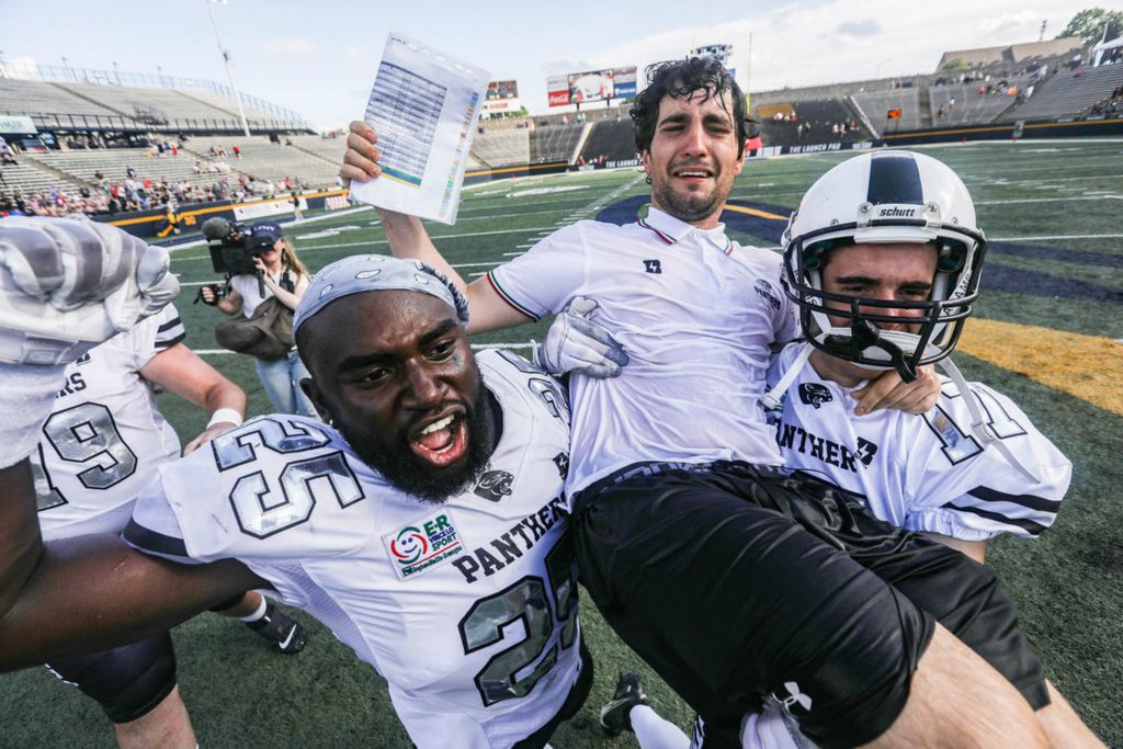 Sports Feature - 1st place - Parma Panthers’ Mpoko Titi (left) and Rocco Bonvicini carries offensive coordinator Sandrino Baci on their shoulders after defeating Florence Guelfi in the Italian Bowl XLII at the University of Toledo’s Glass Bowl. (Rebecca Benson / The Blade)