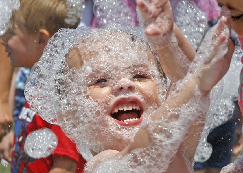 Feature - HM - Adam Hawksworth enjoys the bubbles covering him during the National Trail Parks and Recreation District's Foam Frenzy parties at Northeastern School in South Vienna.  (Bill Lackey / Springfield News-Sun)