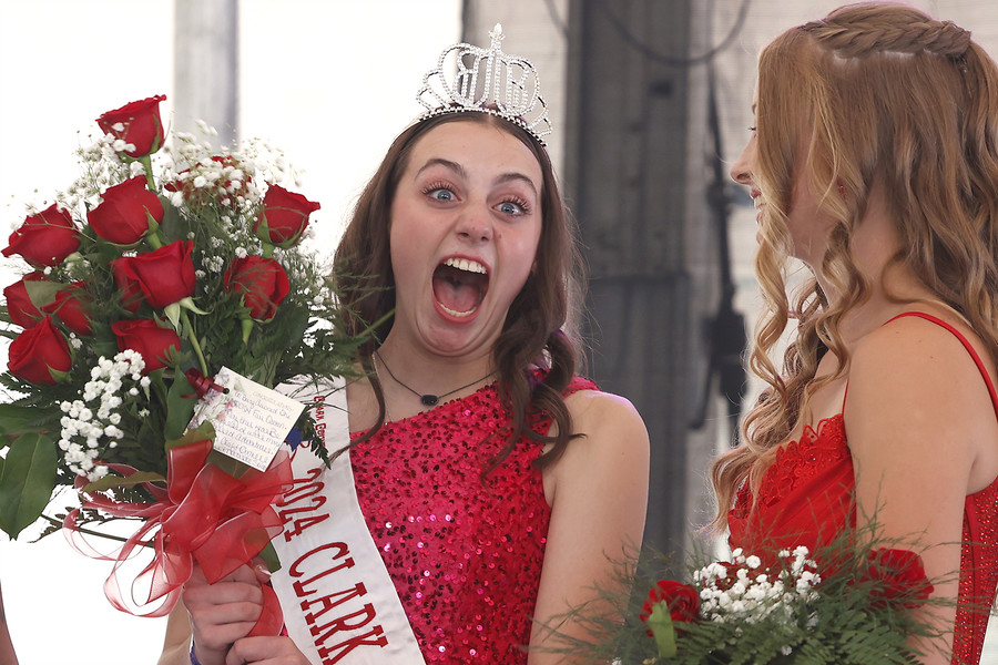 General News - HM - Ellen Getz makes a face of disbelief towards her family as she's presented with a crown, sash and flowers after being announced as the 2024 Clark County Fair Queen on the first day of the fair. (Bill Lackey / Springfield News-Sun)