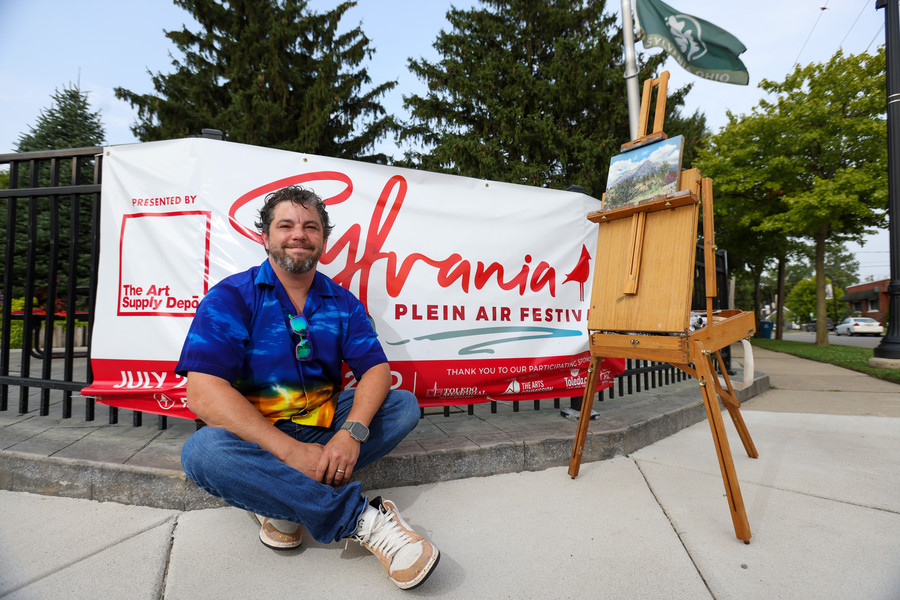 Portrait - HM - Artist Jim Foos poses for a portrait in front of a sign for the Plein Air Festival in Sylvania.  (Jonathan Aguilar / The Blade)