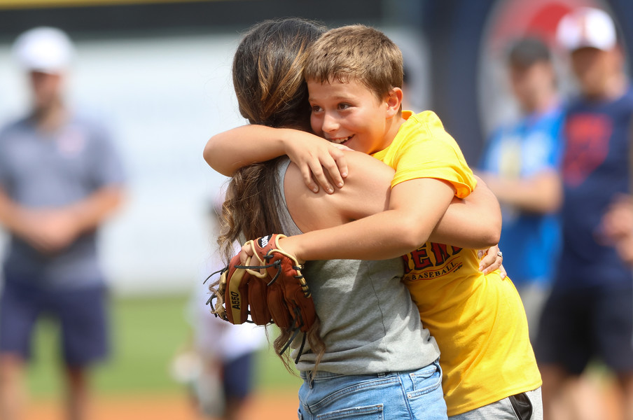 Sports Feature - 1st place - Sydnie Morrobel, home from a nine month Navy deployment, hugs nephew Brayden Rodriguez, 9, after surprising him and catching the first pitch he threw ahead of an International League baseball game between the Toledo Mud Hens and St. Paul Saints at Fifth Third Field in Toledo.  (Kurt Steiss / The Blade)