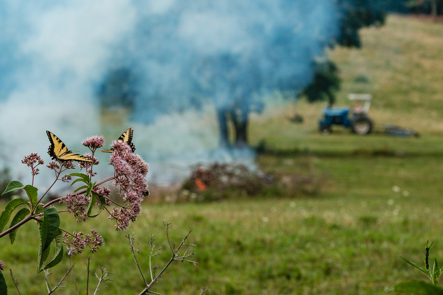 Story - 2nd place - A farmer mows while keeping an eye on a controlled burn of brush on Middle Run Rd NE in Lawrence Township. (Andrew Dolph / The Times Reporter)