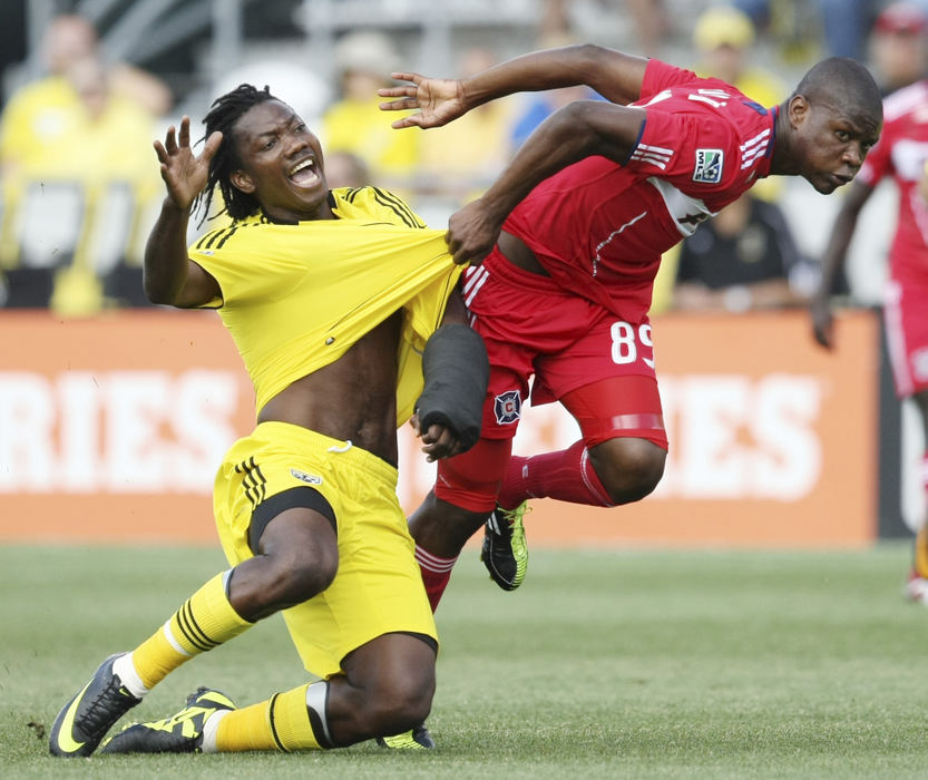 Sports - 2nd place - Columbus Crew forward Andres Mendoza (10) is dragged down by Chicago Fire's Yamith Cuesta (89) in the first period of their game at the Crew Stadium. (Neal C. Lauron / The Columbus Dispatch)