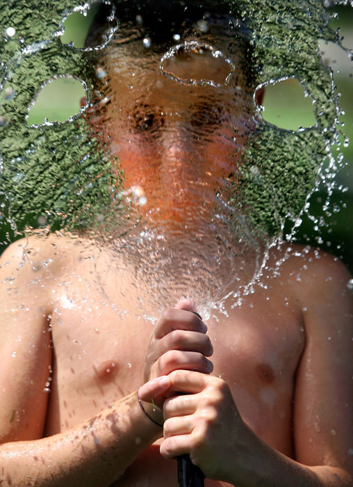 Feature - 1st placeSpencer Sheehan, 11, of Rocky River, sprays a garden hose in his neighbor George Hildebrandt's front yard in Rocky River.  (Lisa DeJong / The Plain Dealer)