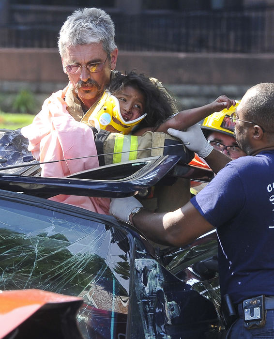 Spot News - 1st placeMembers of the Springfield Fire Division rescue one of the three children from an overturned SUV following a two vehicle crash at the intersection of East High Street and Walnut Street. Five people were involved in the accident, all were transported to the hospital with non-life threatening injuries. (Bill Lackey / Springfield News-Sun)