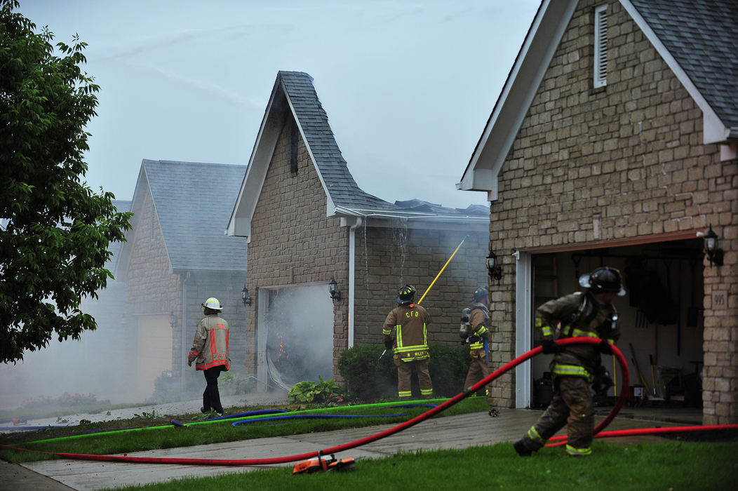 Spot News - 2nd placeFirefighters begin to clean up after much of Marjorie Ramsay's home at 993 Bushwood Lane near Bethel  is destroyed after it was struck by lightning. "I was on the porch reading," said Ramsay. "And all of the sudden I heard this monstrous pop that made me jump. I thought it was a transformer." She called the fire department but all the circuits were busy. She believes the house will be a complete loss. "Oh lordy I just hope the other neighbors roofs are all right." said Ramsay. "I'm going to have to find a new place to live." A storm front with hurricane-force winds blew through central Ohio Friday leaving more than 200,000 people without power and damaging other property.  (Eamon Queeney / The Columbus Dispatch)