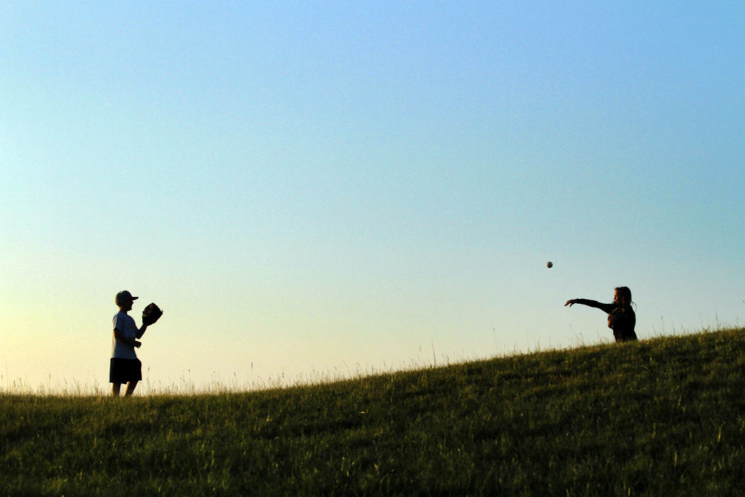 Sports Feature - 2nd placeNew friends Spencer Brooks, 9, and Emily Steinmetz, 10, of North Ridgeville, play catch in the lawn seating area during the game between the Lake Erie Crushers and the Normal CornBelters at All Pro Freight Stadium in Avon.  Many families from North Ridgeville came out to the Tuesday evening game as part of the North Ridgeville Community Day promotion.  (Sam Greene / The (Lorain) Morning Journal)