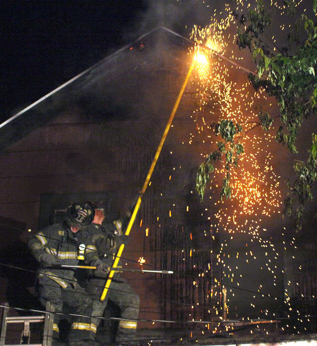 Spot News - First placeAshtabula firefighters use a pike pole to break up a hotspot while battling a fire on W. 9th Street in Ashtabula. (William A. West / )