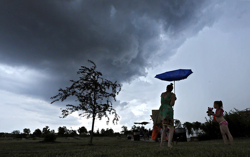 Feature - 1st place - Heater Cochenash along with daughter Jaylynn Cochenash and dog Jamas call it day as a rain and thunderstorm approaches after playing at the spray fountains at Ballantrae Park in Dublin. (Eric Albrecht / The Columbus Dispatch)