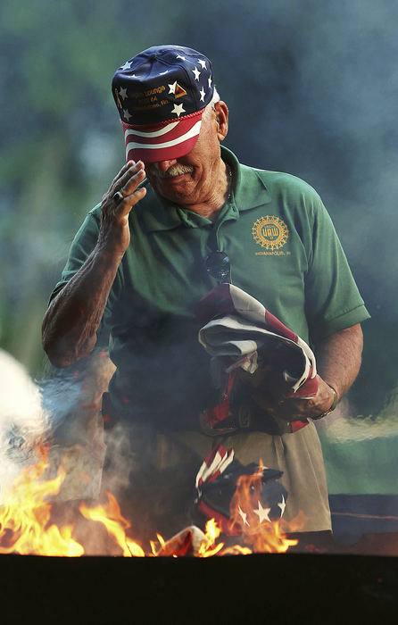 Feature - 2nd place - Ernie Wayman, an army veteran of the "Hell on Wheels" second armored division, offers a flag to be properly incinerated at Southport's annual flag retirement ceremony at Southport Park, Indianapolis on Flag Day. (Jenna Watson / Kent State University)