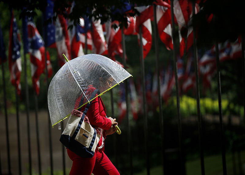 AFeature - HM - Kayla Atchison, of Grandview Heights heads into the Ohio Statehouse for a meeting after a pop-up shower passed through downtown Columbus. As quickly as the rain came on, the skies cleared and sun came back out. More thunderstorms are expected to pass through Central Ohio the rest of the evening.  (Adam Cairns / The Columbus Dispatch)