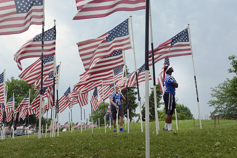 General News - 3rd place - Leo Crosby, 17, places his hand over his heart after planting down a flag honoring fallen U.S. Army PFC. Devin J. Grella during the Flags of Honor ceremony at Zane's Landing Park in Zanesville. The memorial honors Ohio military members who were killed in the Iraq and Afghanistan wars.  (Shane Flanigan / Zanesville Times Recorder)