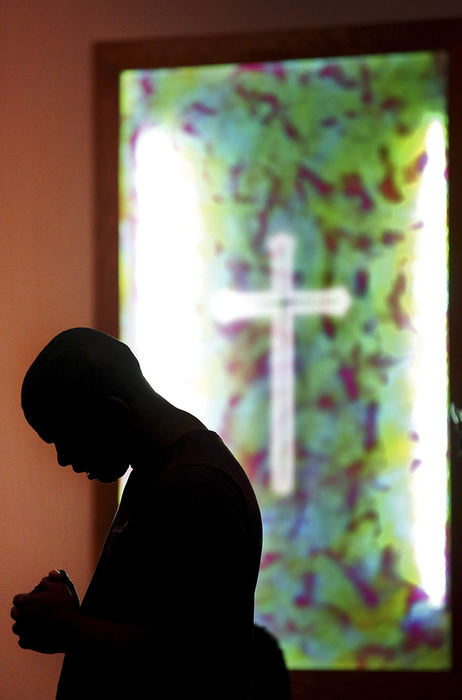 General News - HM - A worshiper at the Corinthian Missionary Baptist Church bows his head in prayer during a remembrance vigil for those killed at the "Mother Emanuel" A.M.E. Church in Charleston, South Carolina. (Chris Russell / The Columbus Dispatch)