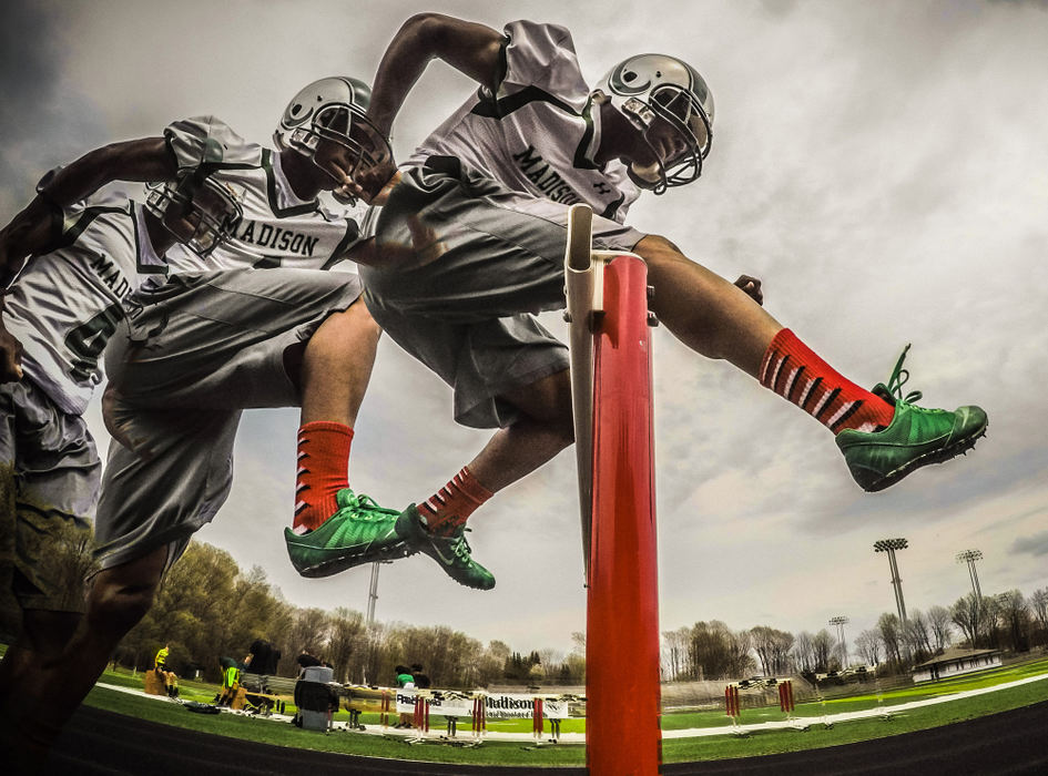 Illustration - 3rd place - Madison track and football player Frank Douglas clears a hurdle.  Frank is one of many high school students who compete in multiple sports. (Mitchell Pe Masilun / The (Mansfield) News Journal)