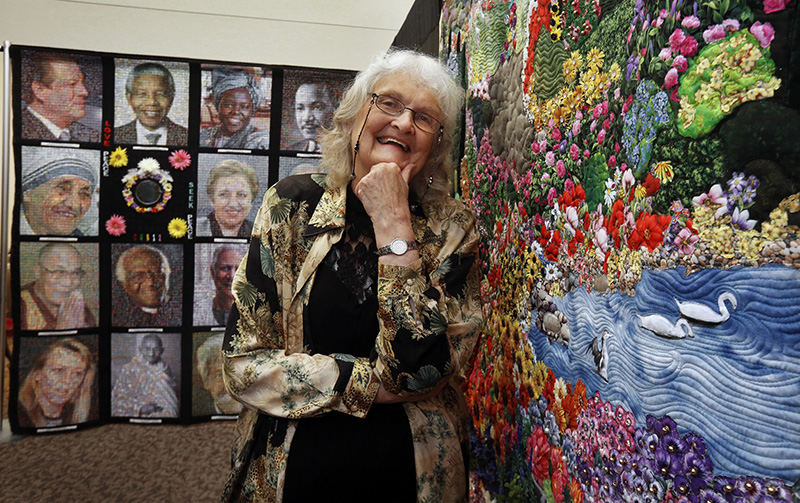 Portrait - 3rd place - Artist Janet McTavish at the exhibit "Peace Labyrinth: Quilting the Golden Rule." exhibit at the  Martin de Porres Center. The "Peace Hero" quilt is on the left, and "The Paece Garden" is on the right.  (Tom Dodge / The Columbus Dispatch)