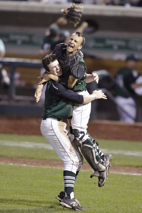 Sports Feature - 1st place - As a glove flies above them, Central pitcher Patrick Murphy leaps into the arms of catcher Nic Millin after defeating Summit in the Division V state championship at Huntington Park in Columbus. (Scott Heckel / The (Canton) Repository)