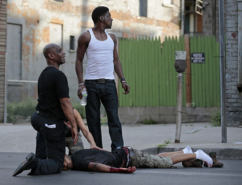 ASpot News - 1st place - State Senator Cecil Thomas (left) and bystanders call out for help as they to tend to a shooting victim as he lay where has was shot during a three-person shootout in the Over-the-Rhine neighborhood of Cincinnati. The victim was transported to University of Cincinnati Medical Center where he died of his injuries. Thomas was in the neighborhood as he was taking part in peace march through the neighborhood just moments before the gunfire.  (Sam Greene / The Enquirer/Sam Greene)