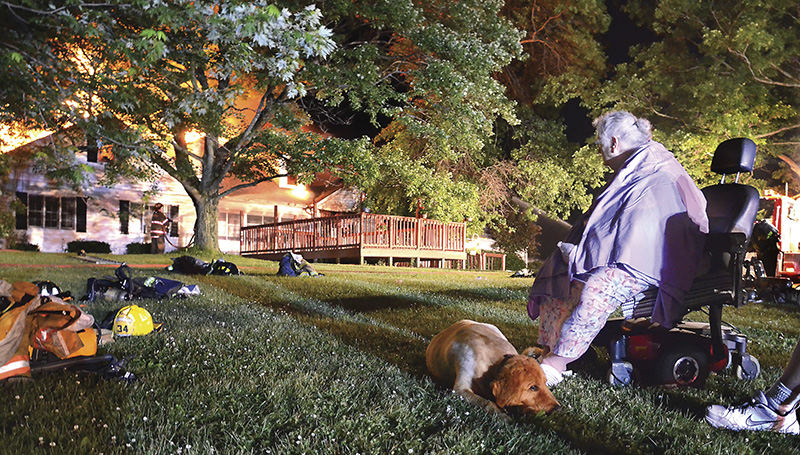 Spot News - 2nd place - Shadyside Home owner Connie Fox and her dog sit outside the burning home. The Shadyside home owned by Fox was a state-certified developmental disabilities facilitty. Fox, who is a registered nurse, was the administrator and resided there.  (Patricia Schaeffer / The (Lisbon) Morning Journal)