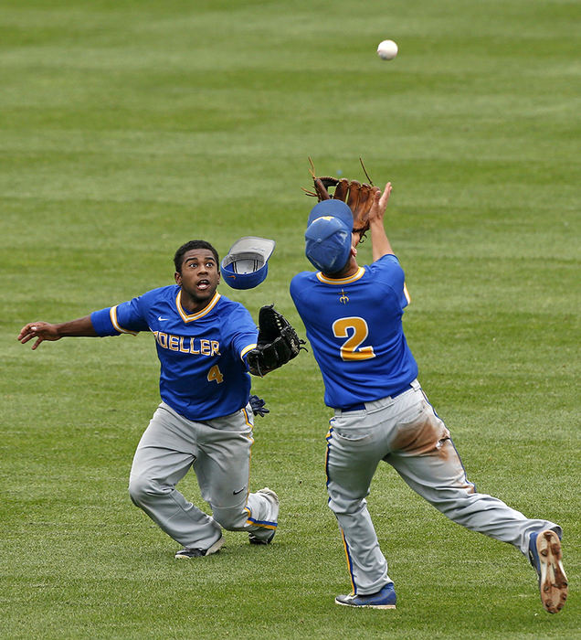 Sports - HM - Jordan Ramey (4) and Kyle Dockus (2) of Moeller both reach for a fly ball in the outfield during their Division I state baseball championship game against Westerville Central at Huntington Park in Columbus. (Barbara J. Perenic / The Columbus Dispatch)