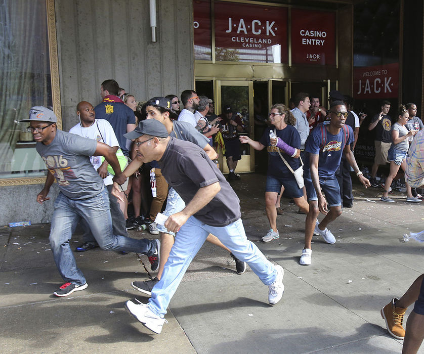 Spot News - 1st place - People run for their lives after a shooting outside the Jack Casino following the Cleveland Cavaliers Championship Parade in Cleveland. (Scott Heckel / The (Canton) Repository)