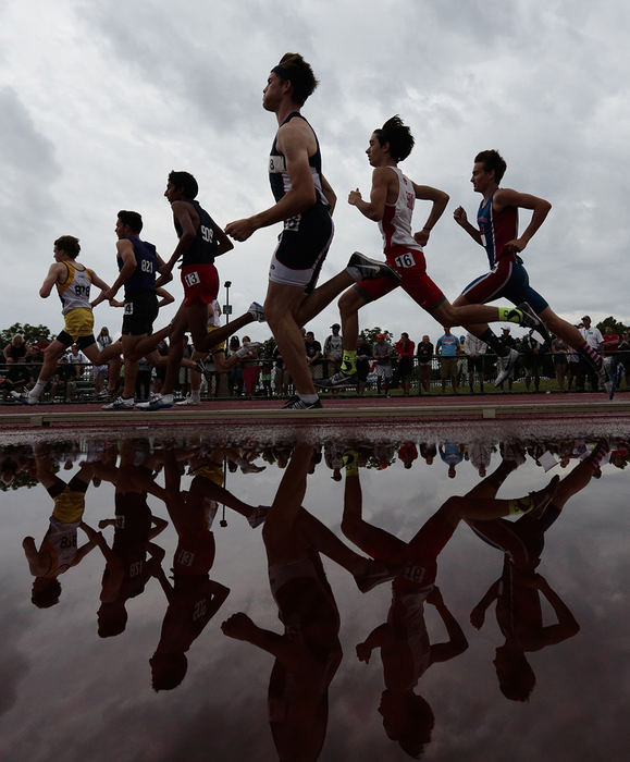 SPSports - 1st place - June  - First Place SportsJoshua A. Bickel/ThisWeek NewspapersRunners in the 1,600-meter run are reflected in a puddle of water during the OHSAA Division I track and field state championships at Jesse Owens Memorial Stadium in Columbus.  (Joshua A. Bickel / ThisWeek Community News)