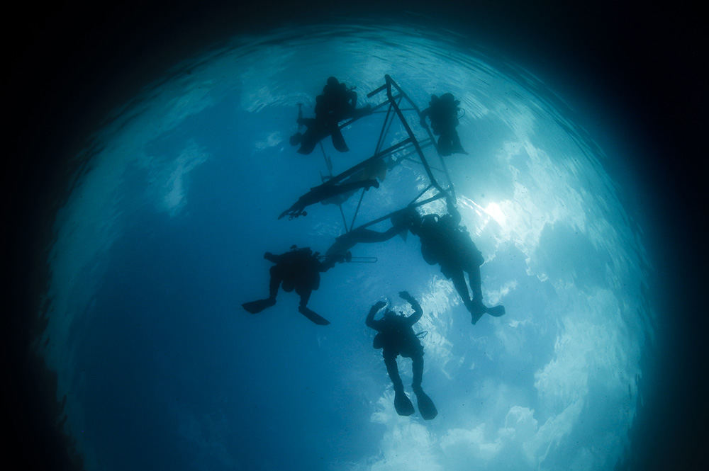 Feature - 2nd place - Divers pull a sculpture made by Craig Whitaker out into White Star Quarry to be sunk as a scuba diving attraction in Gibsonburg. Whitaker, owner of a piano store, made the underwater orchestra after being inspired from seeing sunken sculptures on his dive trips. (Andy Morrison / The Blade)