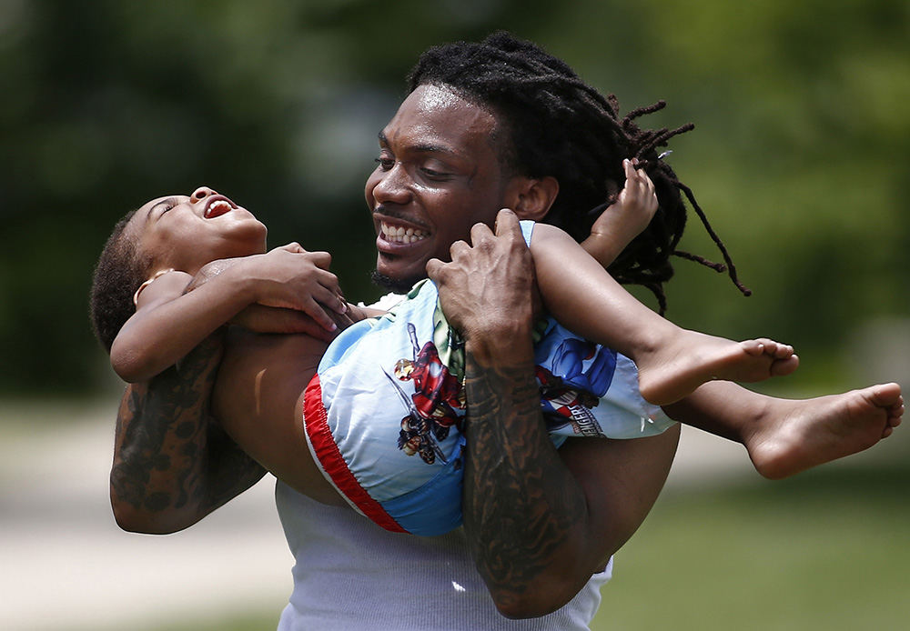 Feature - 3rd place - Pierre Harris Sr. spins his son, Pierre Harris Jr., in circles near the Scioto Mile Fountain. A dizzy Pierre Jr. laughed as he was being spun, but told his dad later that it wasn't fun.  (Fred Squillante / The Columbus Dispatch)