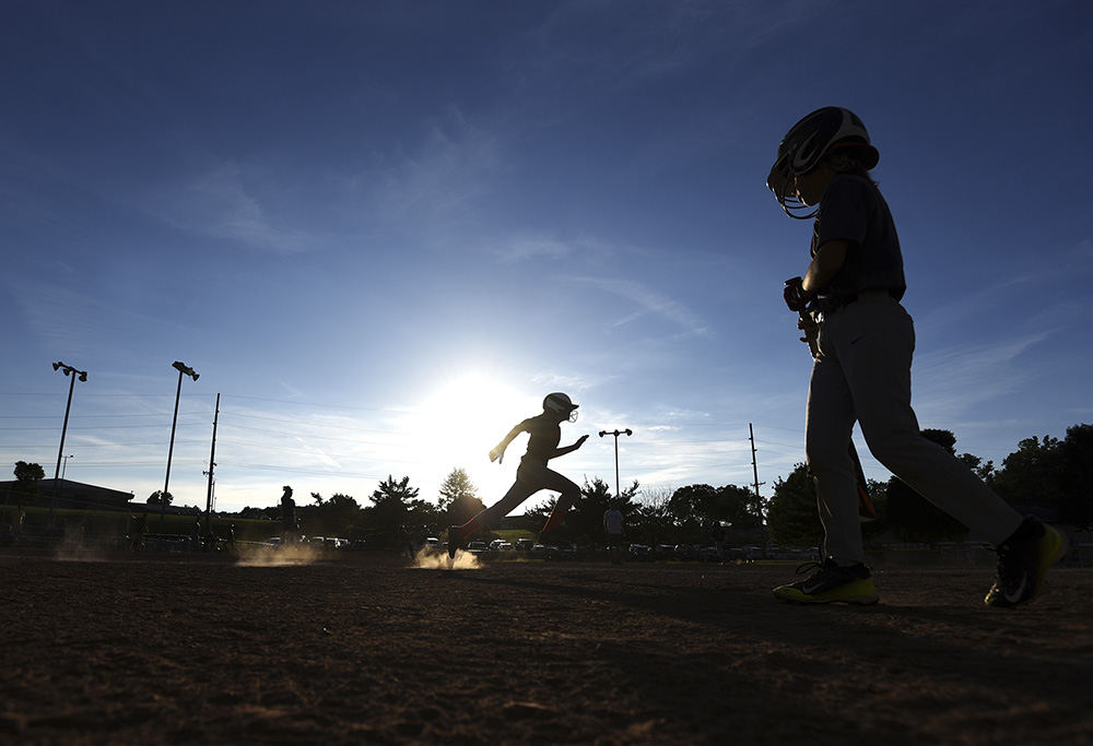 Sports Feature - 1st place - A player springs toward first base as another player makes his way to the plate during a Muskingum Youth Baseball league game in Dresden. (Chris Crook / Zanesville Times Recorder)