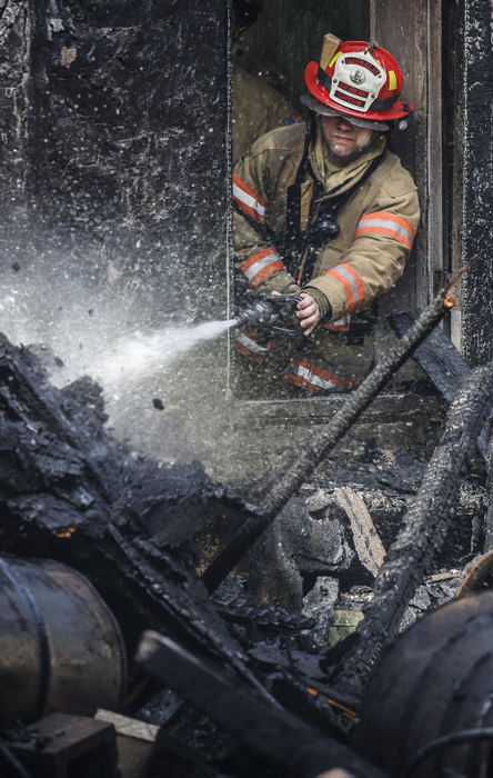 Spot News - 1st place - Allen-Clay Joint Fire District Captain Tim Davies pours water on an old railroad hub at the corner of Washington and Sixth in Genoa during a fire. (Andy Morrison / The Blade)