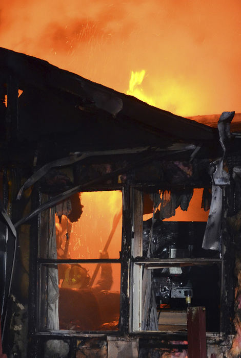 Spot News - 3rd place - Lisbon firefighters Tony Hunt and Adam McCullough make an attack from the inside a mobile home to knock down stubborn fire burning in the roof of the trailer.  (Patrica schaeffer / The (Lisbon) Morning Journal)