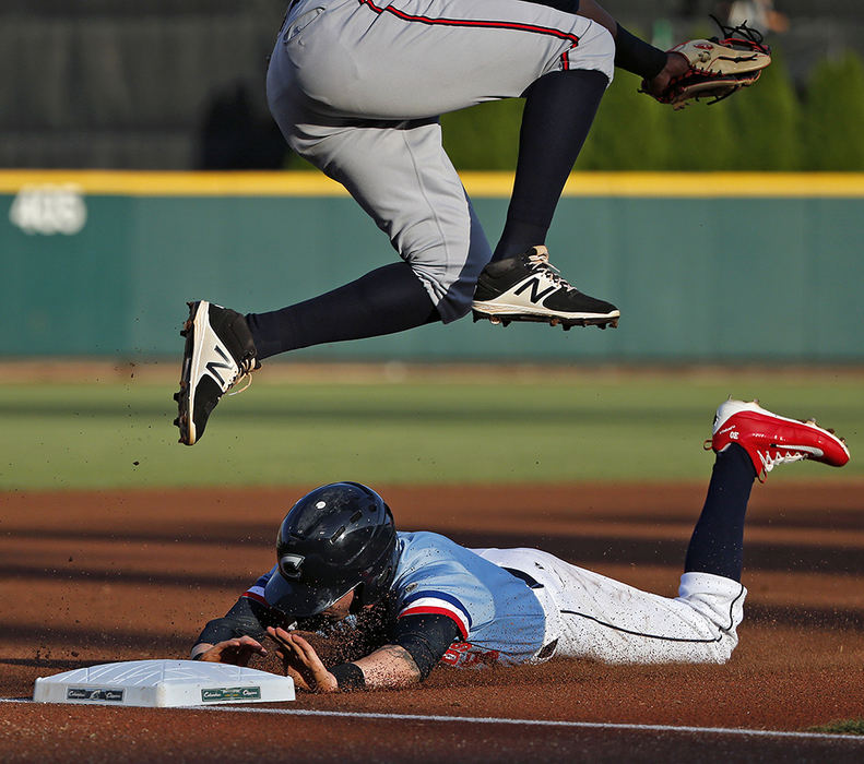 Sports - 2nd place - Columbus Clippers center fielder Tyler Naquin steals third base as Gwinnett Braves third baseman Carlos Franco (58) jumps over Naquin during their game at Huntington Park in Columbus.   (Kyle Robertson / The Columbus Dispatch)