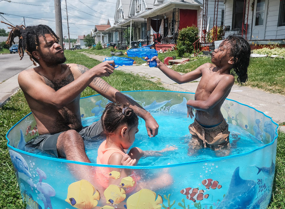 Feature - 3rd placeHeem Summeria (left) plays with his children Anicasio Summeria, 6, (right) and Nida Summeria, 4, in a Kiddie pool on Buffalo Street in Toledo. (Jeremy Wadsworth/The Blade)