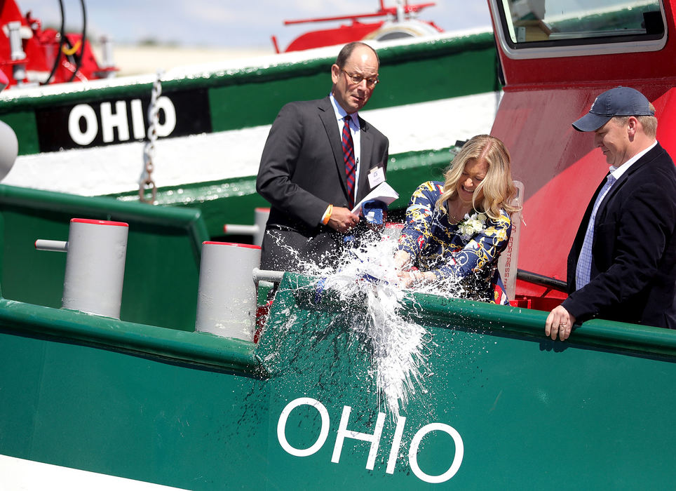 General News - HMJulie LaMarre (center) christens the new Tug Ohio while flanked by Joe Starck, Jr., who is president of the Great Lakes Towing Company and Great Lakes Shipyard (left) and her husband, Paul LaMarre III, a member of the museum's directing board and director of the Port of Monroe (right) during the dedication and christening ceremony of the old Tug Ohio and new Tug Ohio at the National Museum of the Great Lakes in Toledo. (Kurt Steiss/The Blade)