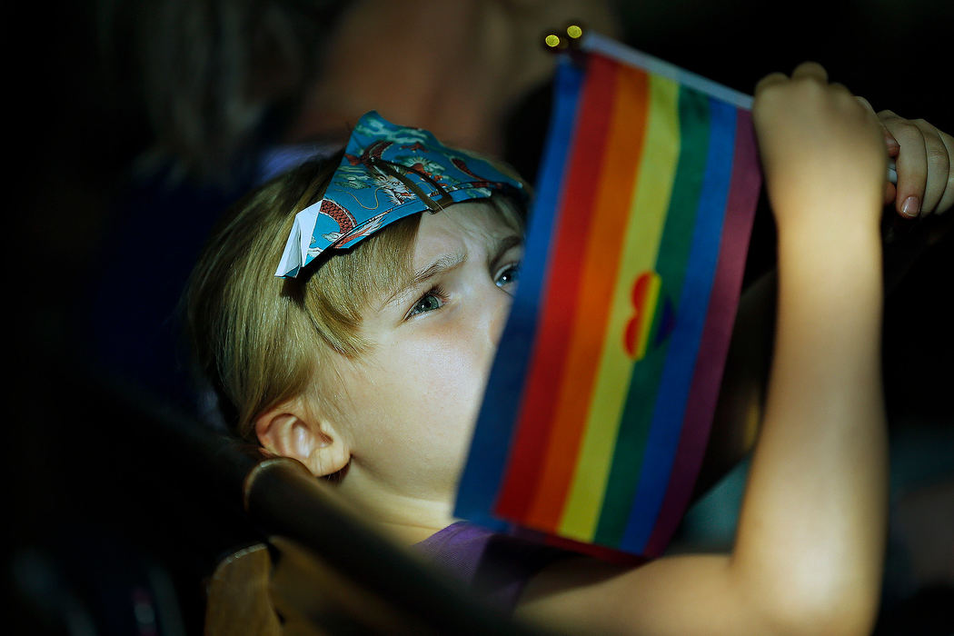 General News - HMPiper Sigloch, 7, waves two rainbow flags before the start of Pride worship service at Maple Grove United Methodist Church in Columbus. (Kyle Robertson/The Columbus Dispatch)