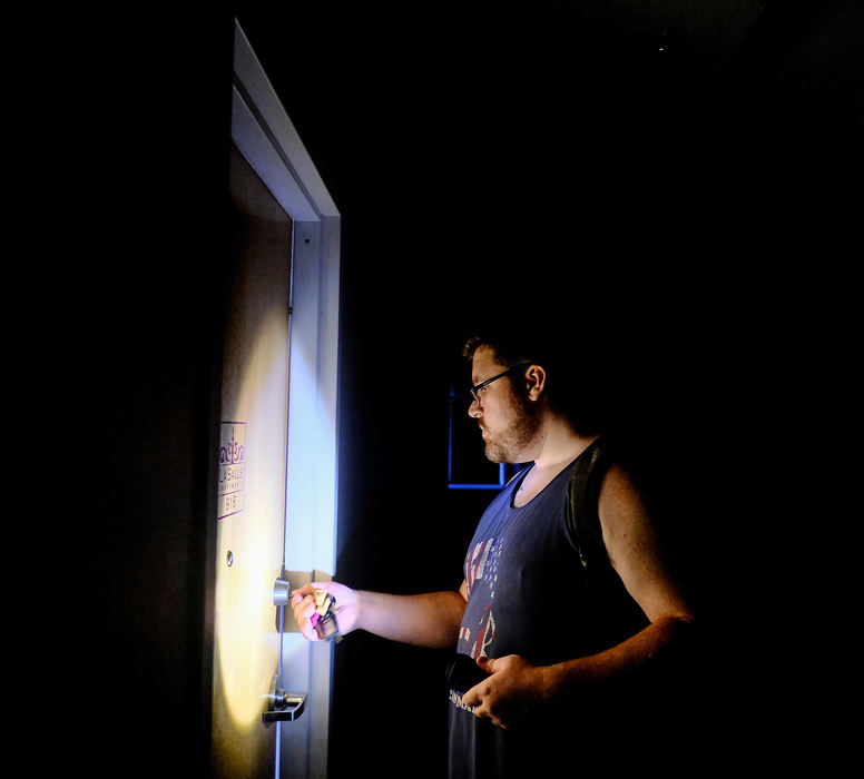 Spot News - HMCaleb Agner uses a flashlight to navigate the dark halls to get to his apartment on the 9th floor of the LaSalle Building in Toledo. The building lost power when construction crews hit an underground cable. (Jeremy Wadsworth/The Blade)