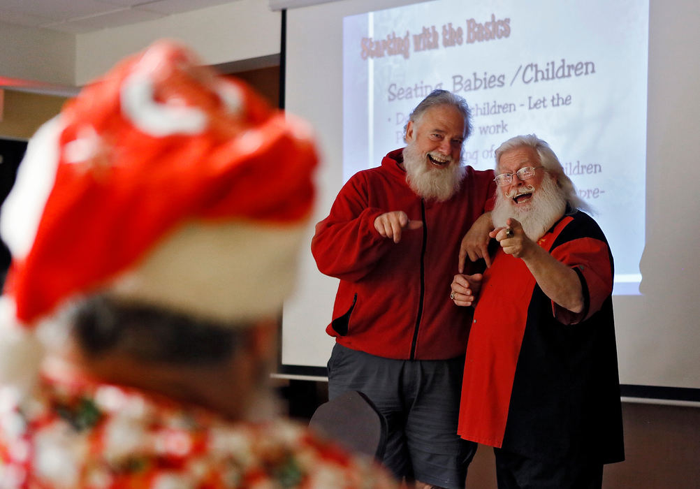 Story - HMTim Connaghan teaches Bob Roumeliote (left) to say yeah to get a more natural smile at the School4Santa during the photo sessions that might happen at a corporate event.(Eric Albrecht/The Columbus Dispatch)