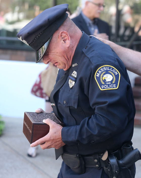 General News - 3rd place - Massillon police officer Miguel Riccio reacts while carrying the ashes of his K-9 Inca during a remembrance for the police dog at Duncan Plaza in Massillon. (Scott Heckel / The Canton Repository)