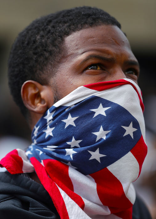 Portrait - 2nd place - Abraham Millender of Akron covers his face with a U.S. flag as he looks up at the Harold K. Stubbs Justice Center during a protest against police brutality in Akron. (Jeff Lange / Akron Beacon Journal)