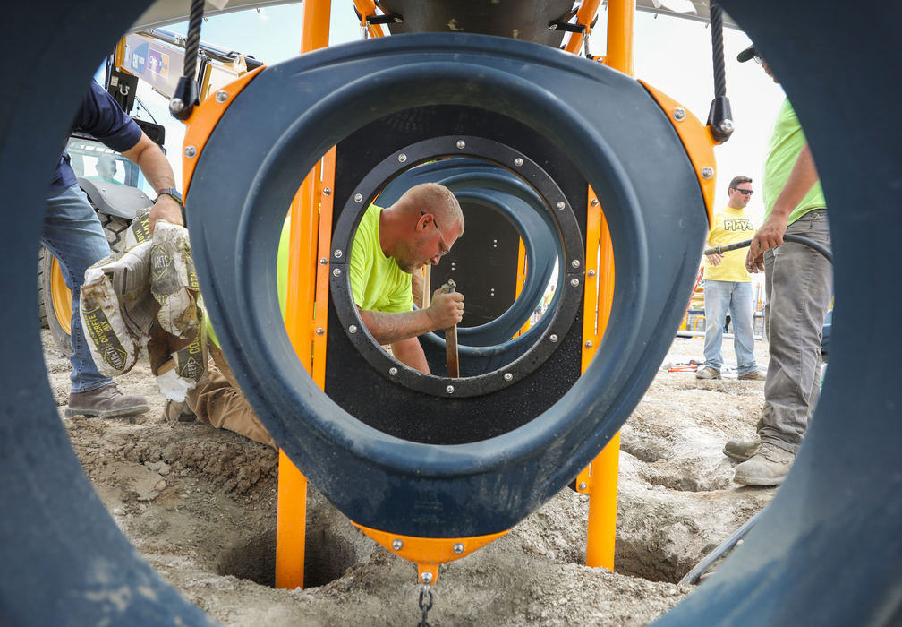 General News - 1st place - Volunteer Skyler Minkler, with Millwright Local 1090 (center) pours and mixes concrete as he and others work on Perrysburg Inclusive Playground presented by Mercy Health at Rotary Community Park in Perrysburg. (Kurt Steiss / The Blade)