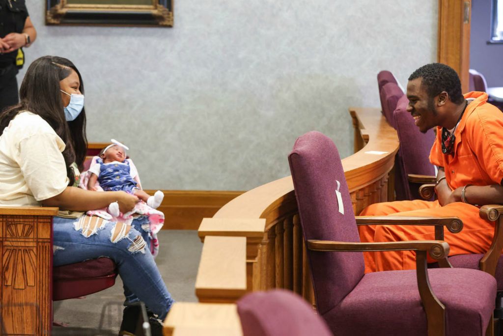 General News - 3rd place - Rashad Mathis smiles as he meets his newborn daughter Avaya Mathis, 2 weeks, as her mother Delisha Starks holds her in Judge Dean Mandros’ courtroom at the Lucas County Courthouse in Toledo. Judge Dean Mandros allowed Rashad Mathis to meet his newborn daughter before his sentencing next week.  (Rebecca Benson / The Blade)