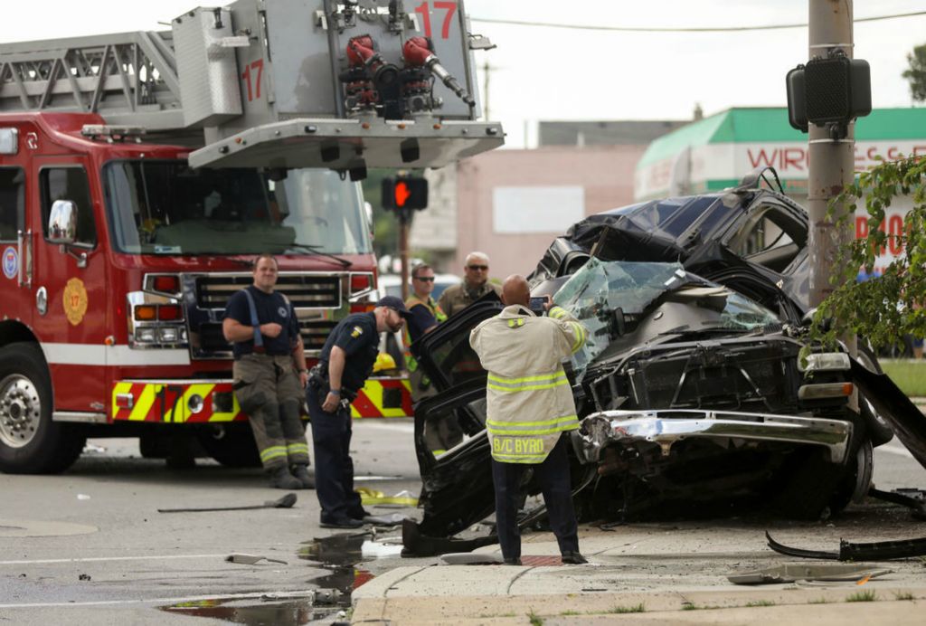 Spot News - 2nd place - Fire Chief Brian Byrd takes a photo of the scene where a vehicle rests after it crashed into a fire truck and utility pole at Auburn Avenue and Monroe Street in Toledo. A passenger was injured and the driver died as a result of the incident.  (Kurt Steiss / The Blade)