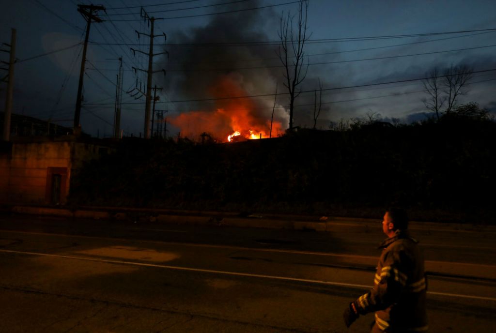 Spot News - 3rd place - A firefighter walks in front of a blaze as firefighters battle it at a scrapyard on East Laskey Road in Toledo. (Kurt Steiss / The Blade)