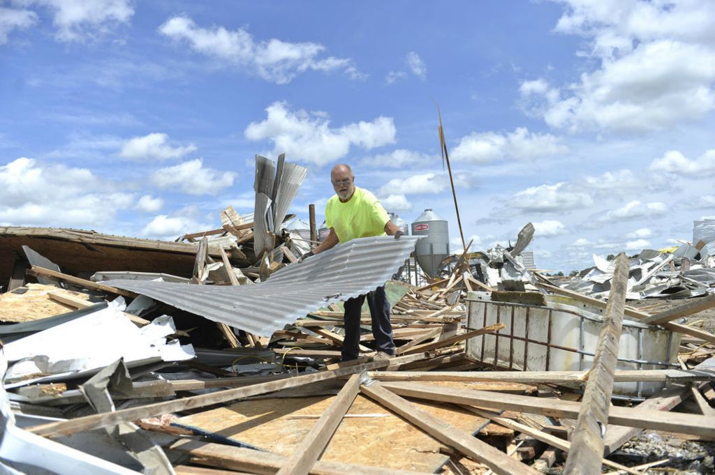 Story - 2nd place - Dutch Thobe helps with the cleanup at Dave and Marie Link's hog farm in Fort Recovery after a tornado inflicted extensive damage to the farm. (Daniel Melograna / The Daily Standard)