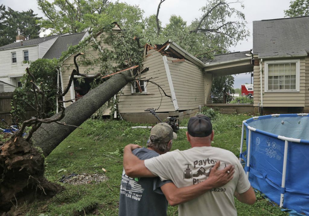 Spot News - 1st place - Rob Howard (left) is comforted by his friend Kevin Dancy as they look over the large tree that crushed Howard’s garage in the 2500 block of Mechanicsburg Road near Springfield. An F1 tornado was confirmed to have touched down in the area causing extensive damage.  (Bill Lackey / Springfield News-Sun)