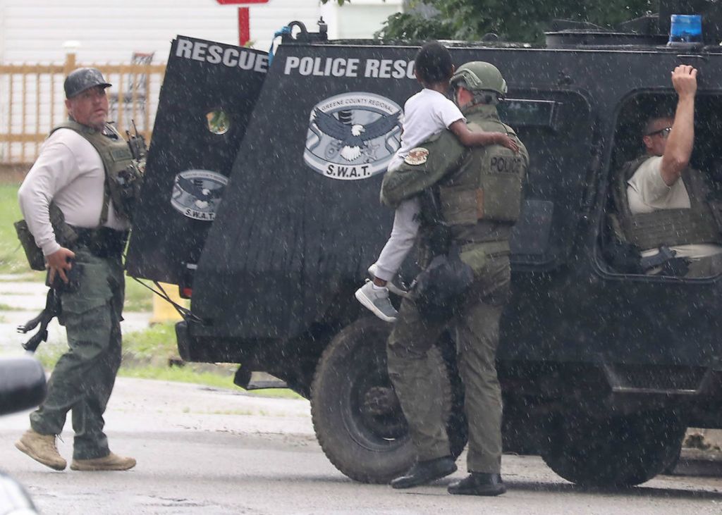 Spot News - 3rd place - A police officer carries a young boy to an armored vehicle after he was removed from a house along South Lowry Avenue where a stand-off had been going on for several hours. The boys father, wanted for an outstanding warrant, had armed himself and refused to exit the house or let his son go free.  (Bill Lackey / Springfield News-Sun)