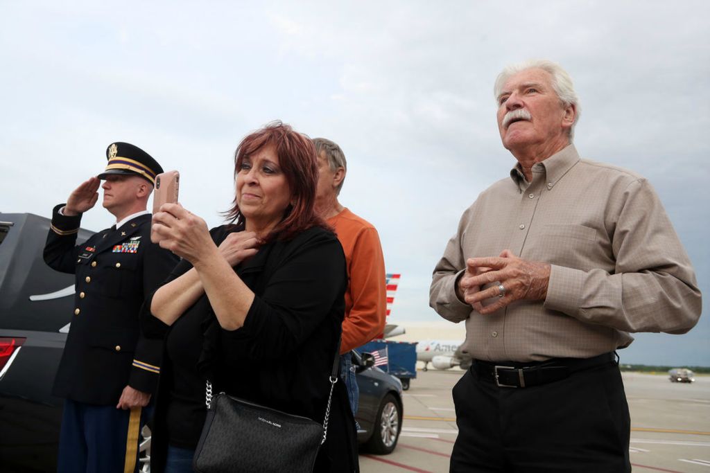 Story - 2nd place - Major Jason Brand, Ohio Army National Guard, salutes as David Lilley, of Westerville, and Melanie Clifford, of Pigeon Forge, Tenn., patiently wait for the remains of Korean War Army veteran private first class Jack E. Lilley to be removed from an American Airlines flight from Honolulu on June 10 at John Glenn Columbus International Airport. Pfc. Lilley, who is David's brother and Melanie's second cousin, was killed during the war on July 20, 1950 and was reported missing in action before his remains were identified Nov. 5, 2021. (Shane Flanigan / ThisWeek Community News)