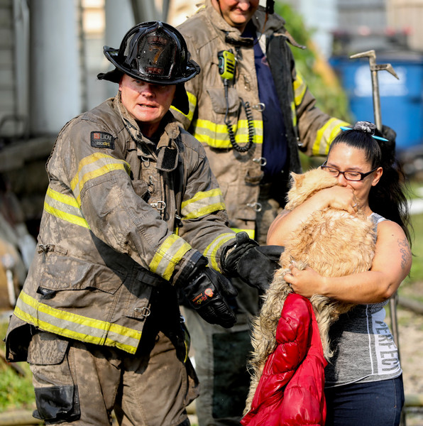 Spot News - 3rd place - A firefighter hands Whiskers, a 3-year-old cat, to Rosa Gomez after rescuing the feline from a fire at a residence at Valleywood Drive and Nevada Street in East Toledo. (Kurt Steiss / The Blade)