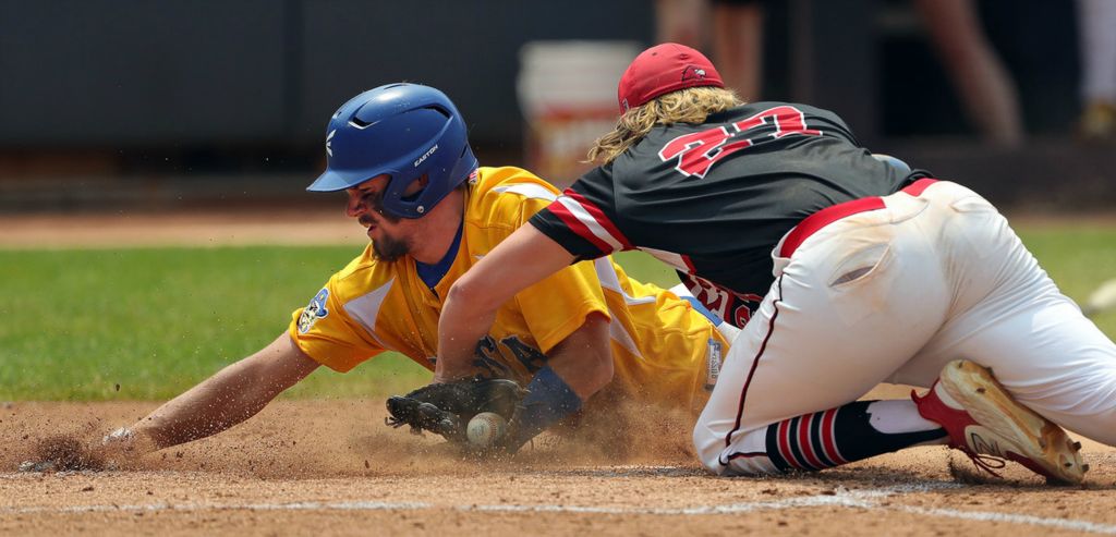 Sports - 2nd place - Russia baserunner Ross Fiessinger, (left) scores a run past Hiland pitcher Will Schlabach during the fourth inning of the OHSAA Division IV state championship game at Canal Park in Akron. (Jeff Lange / Akron Beacon Journal)