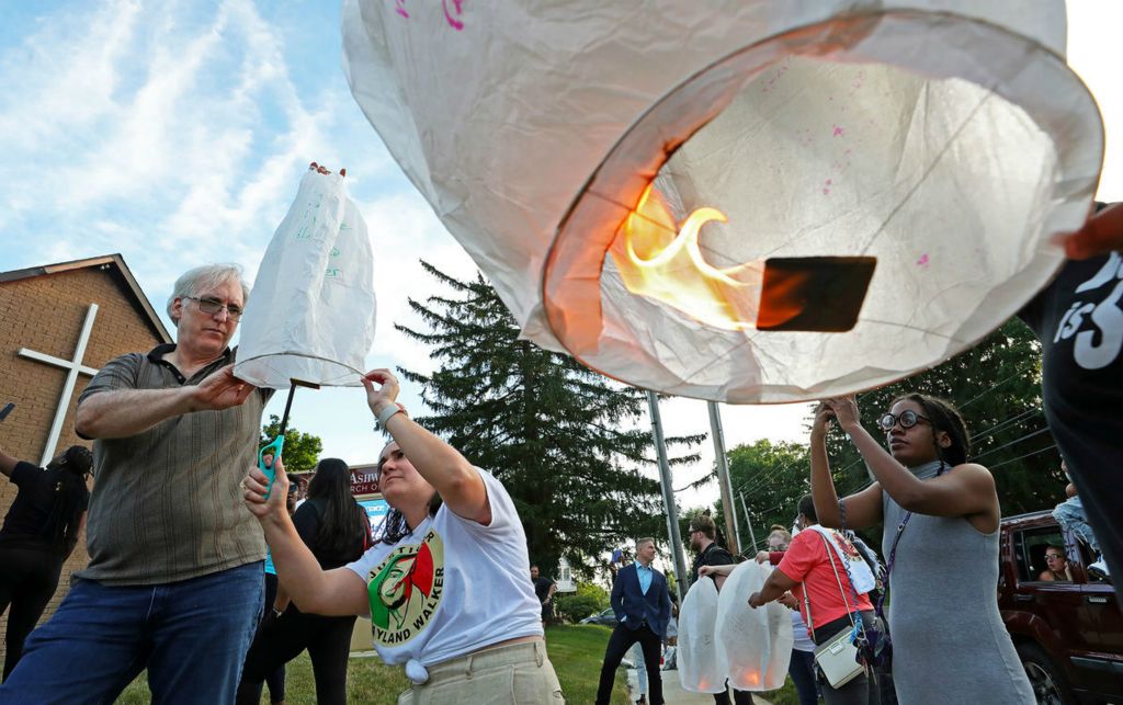 General News - 3rd place - David Guran of Akron, (left) and Betta Deblasio of Tallmadge light paper lanterns during a memorial for Jayland Walker, a 25-year-old Black man who was shot and killed by Akron Police two years ago. (Jeff Lange / Akron Beacon Journal)