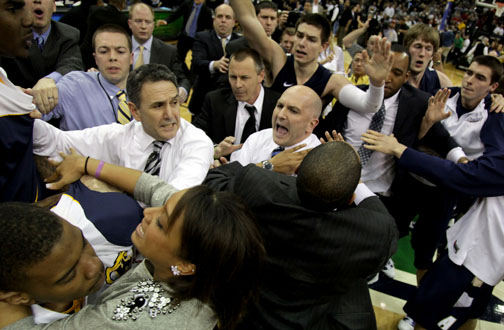 Sports - 3rd place - Akron head coach Keith Dambrot and Kent State head coach Geno Ford attempt to separate players and staff after a scuffle occurred at the end of Akron's 66 to 65 overtime win over Kent State in the men's  MAC Tournament championship game at Quicken Loans Arena in Cleveland.   (Marvin Fong / The Plain Dealer)